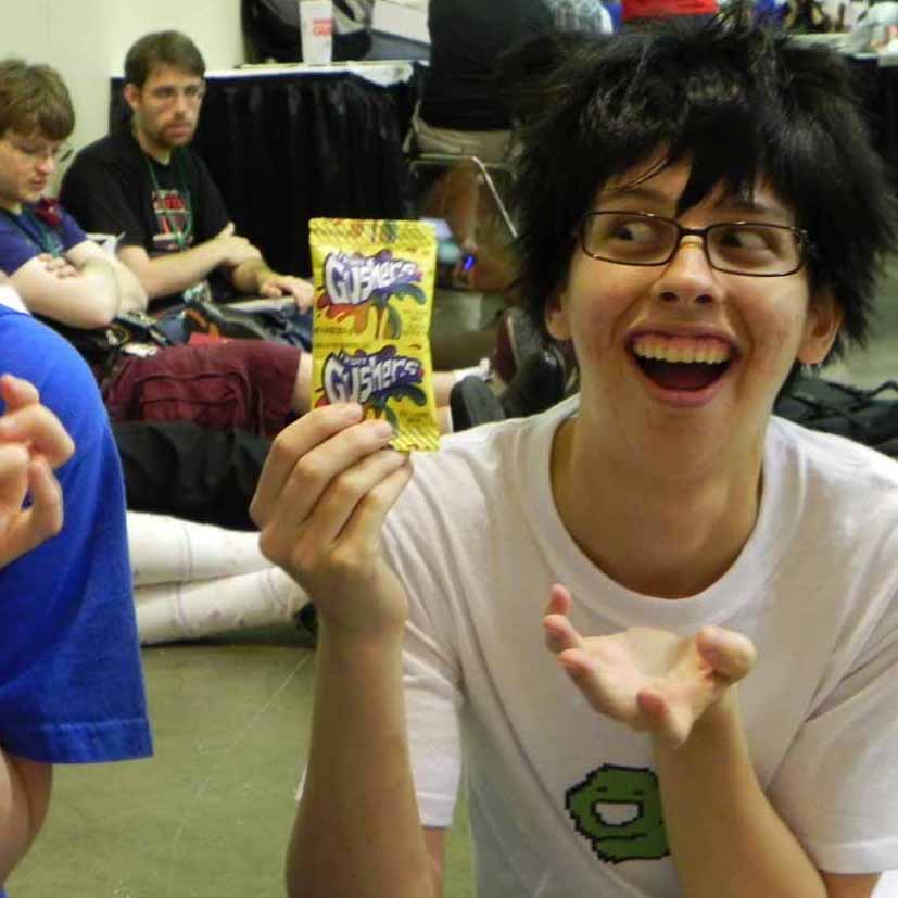 Posing in costume, holding up a pack of Fruit Gushers.