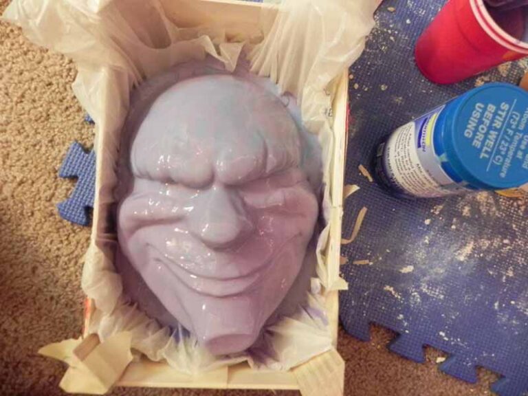 Pouring silicone over the clay mask to form the mold.