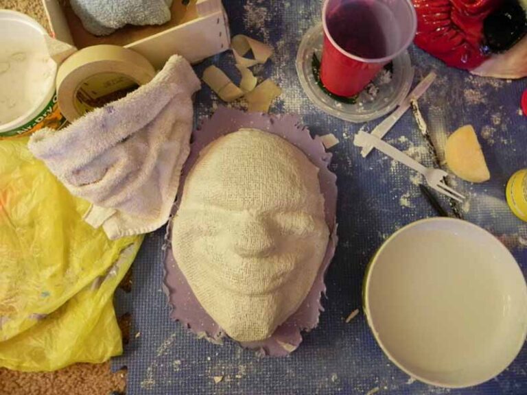 Adding a reinforcing plaster bandage mold to support the silicone mold of the mask.