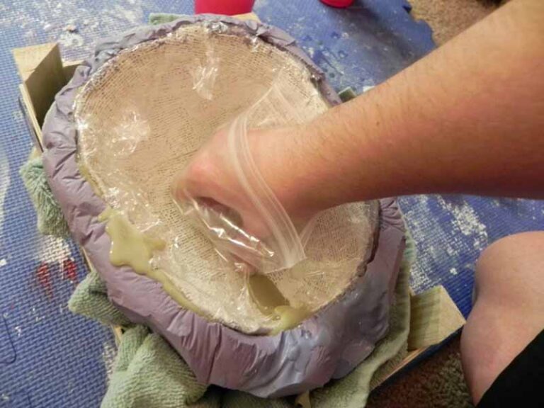 Pressing the original face cast into the back of the silicone mold, to create a concave shape in the curing resin.