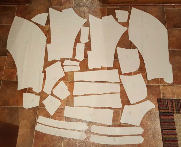 Paper sewing patterns cut out and laid on the floor, ready for tracing.
