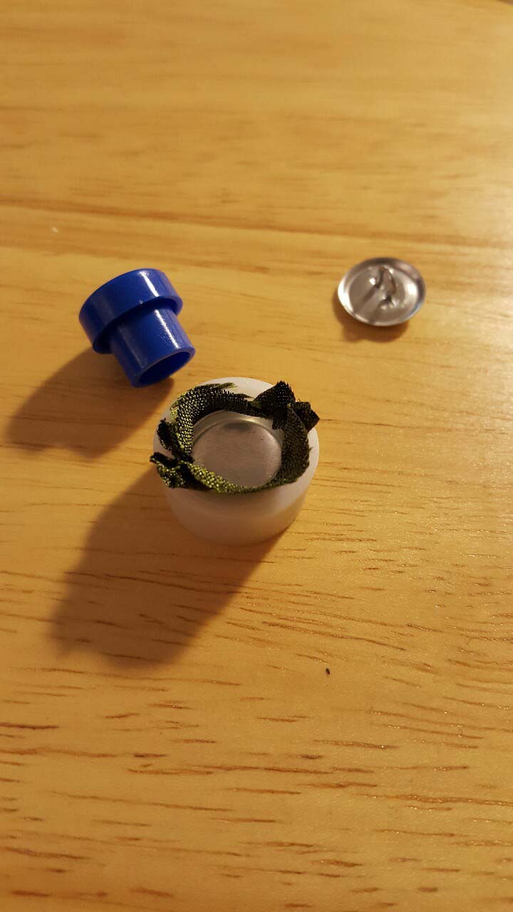 Close-up of a button press, creating a matching button using fabric from the jacket.