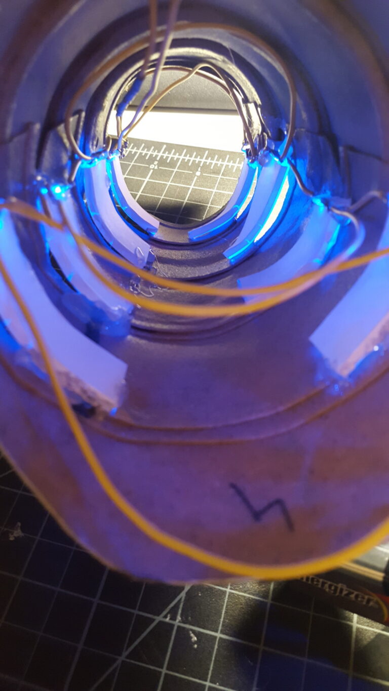 Close-up shot of the inside of the robotic forearm piece, showing the wiring for the blue LED lights.