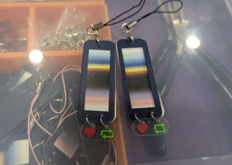 Keychains made from cut-out vinyl, made to look like the gradient on a Tumblr post. The like and reblog icons are dangling from the bottom of the keychain on a separate transparent piece.